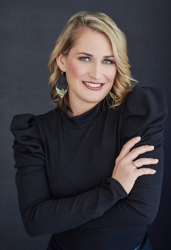 Beautiful smiling white woman with short blonde hair wearing a black dress. Professional headshot and glamour shot.