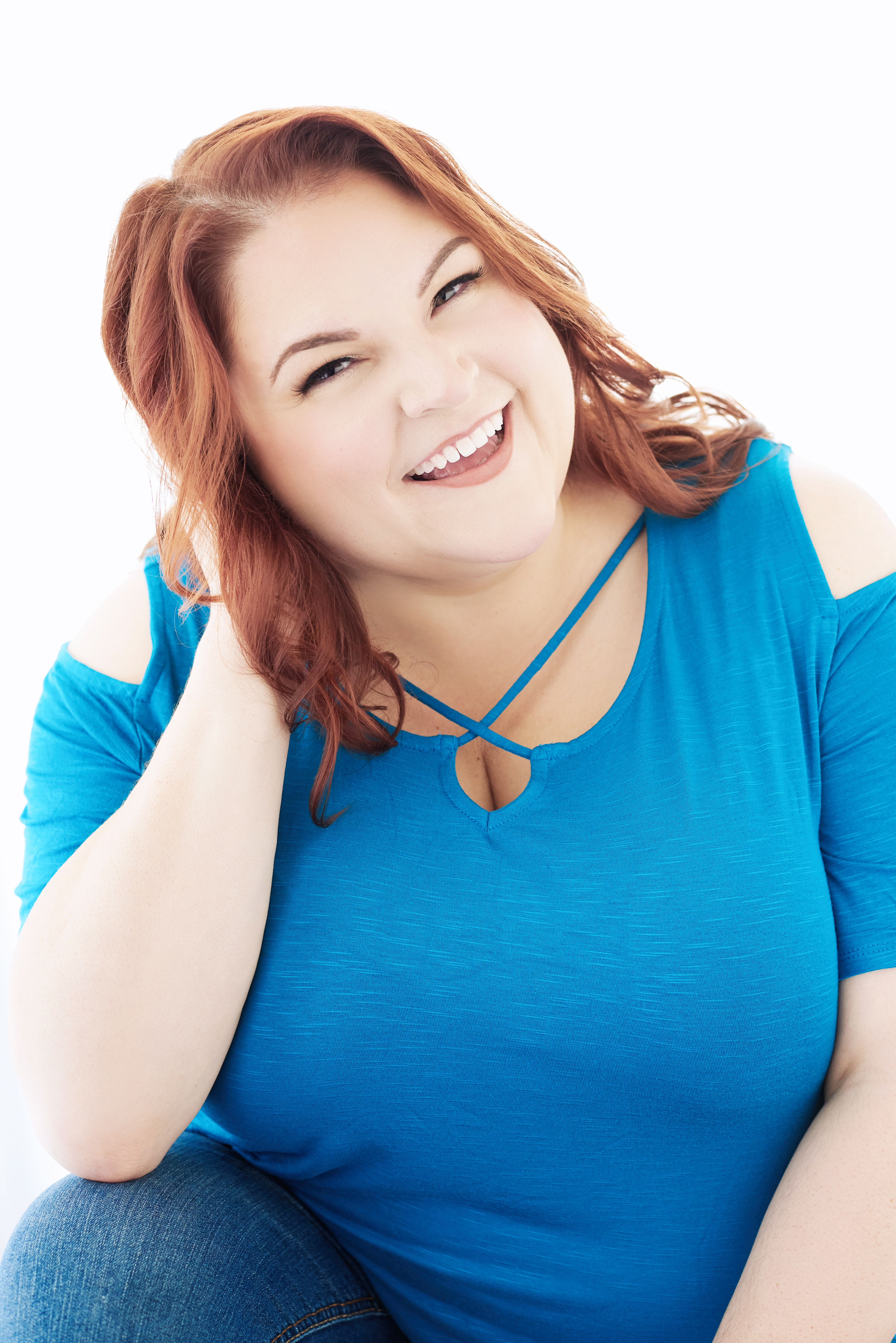 Beautiful laughing/smiling white woman with red hair wearing a blue t-shirt.